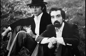 Robbie Robertson and Martin Scorcese sit next to each other on the grass in Central Park.