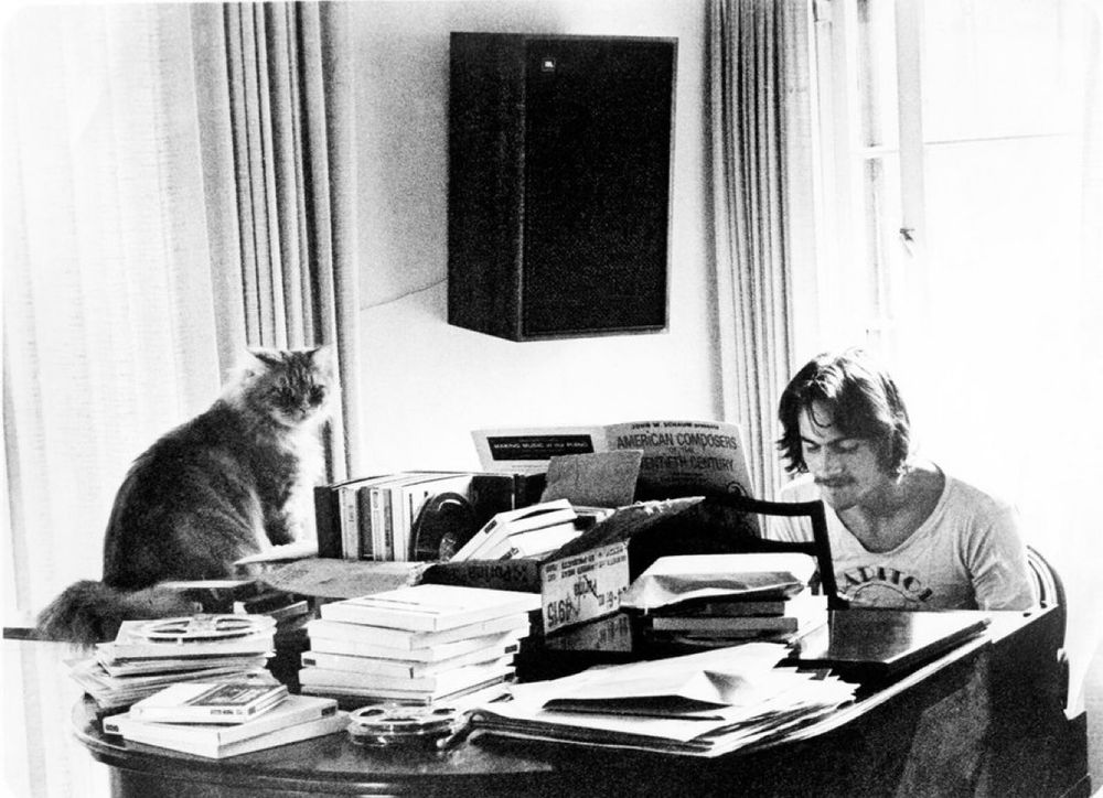 Taylor at the piano. His large long-haired cat sits listening. 