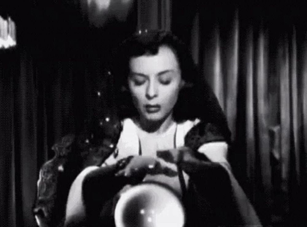 a woman is sitting in a chair holding a crystal ball in her hand .