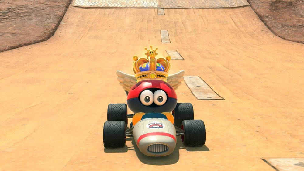 A Para-Biddybud in the B-Dasher in Wario Stadium, as depicted in Mario Kart World. The Para-Biddybud has a crown atop its head.
