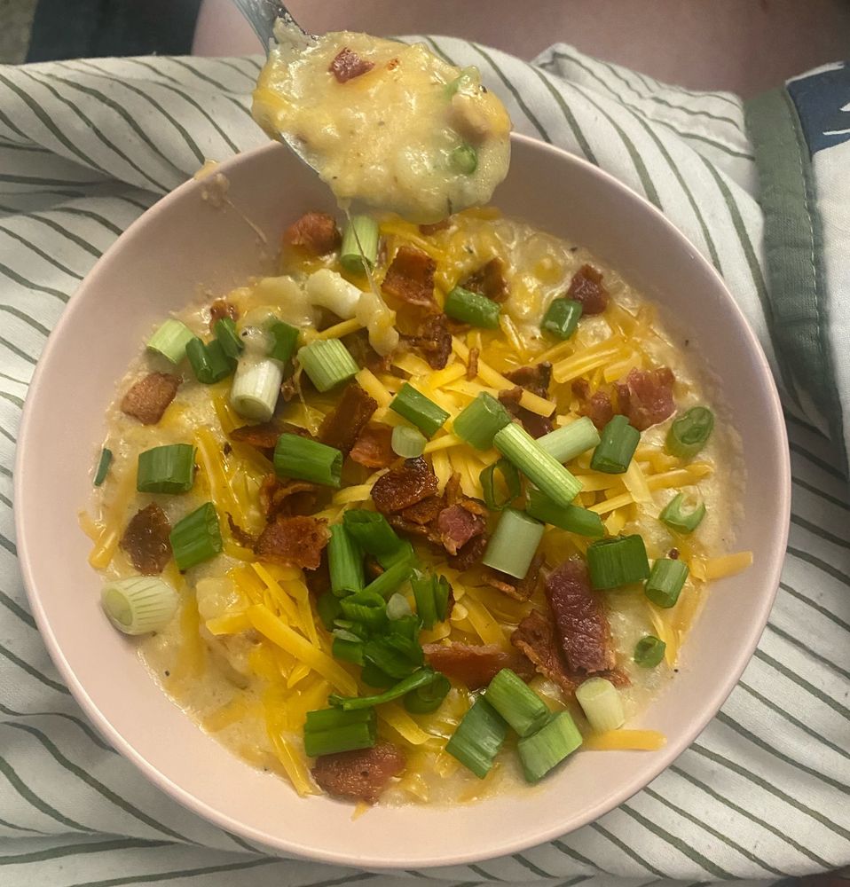 potato soup garnished with shredded cheddar cheese, crumbled bacon, and chopped green onion. 