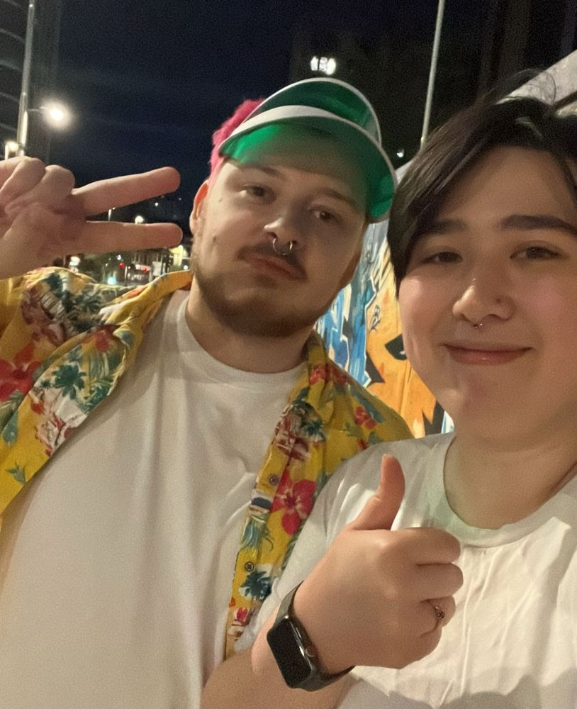selfie of two slightly drunk guys one is wearing an obnoxious flowery yellow shirt and a stupid pub golf visor 