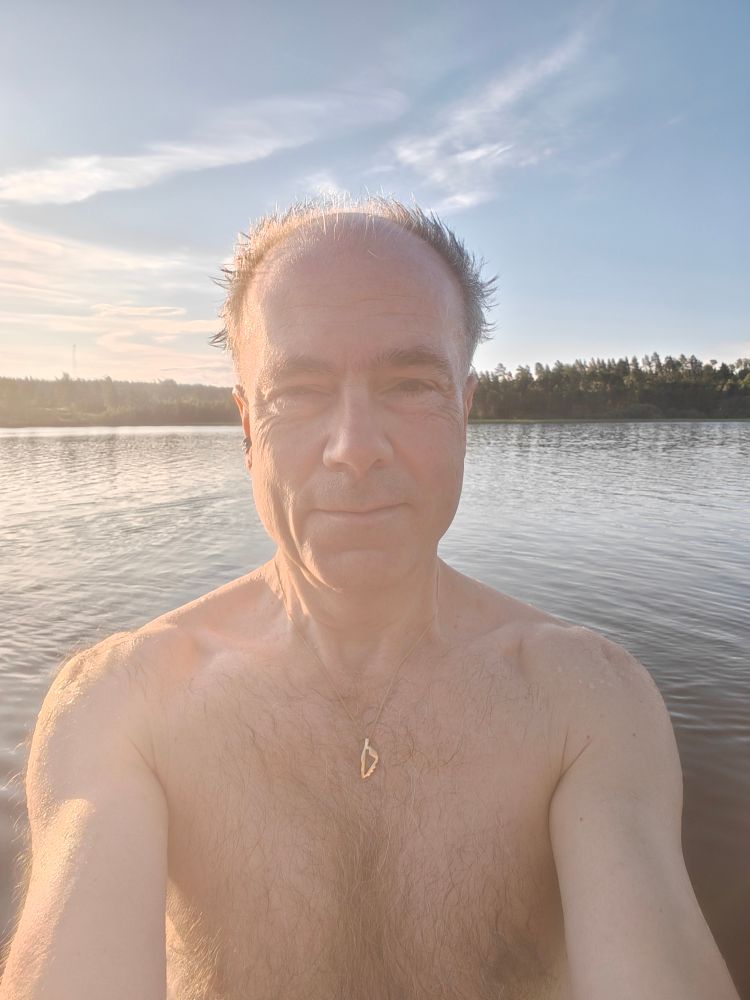 Bad-selfie av gubbe vid sjö 