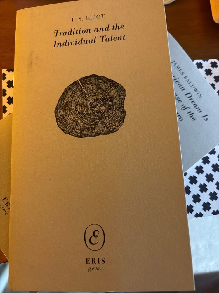 A grey chapbook with the image of a tree trunk cut laterally so the rings are visible and the title "Tradition and the Individual Talent" by T S Eliot, published by Eris gems.