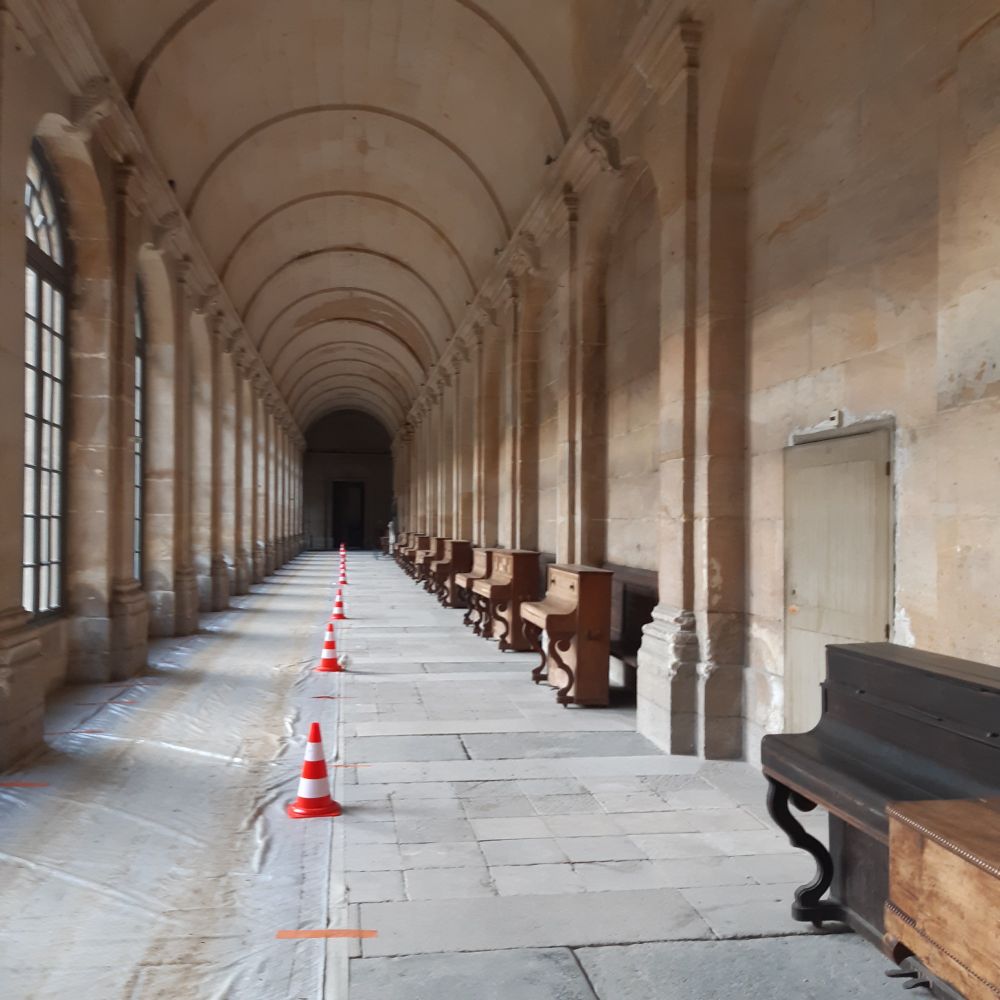 Une galerie début XVIIIème avec un alignement de pianos et de plots signalant des travaux