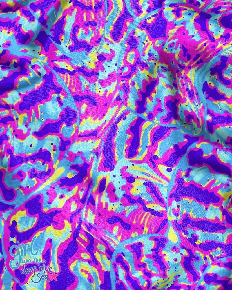a photo of a colourful fabric with an abstract pattern inspired by the colours and shapes of giant clams. The colours are purple, blue, yellow, and pink. 