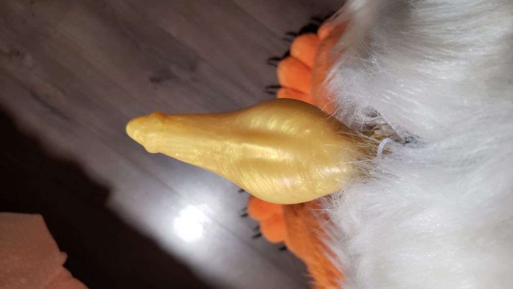 Orange fox fursuit, yellow knotted taper dildo poking out of the crotch, taken from above looking down