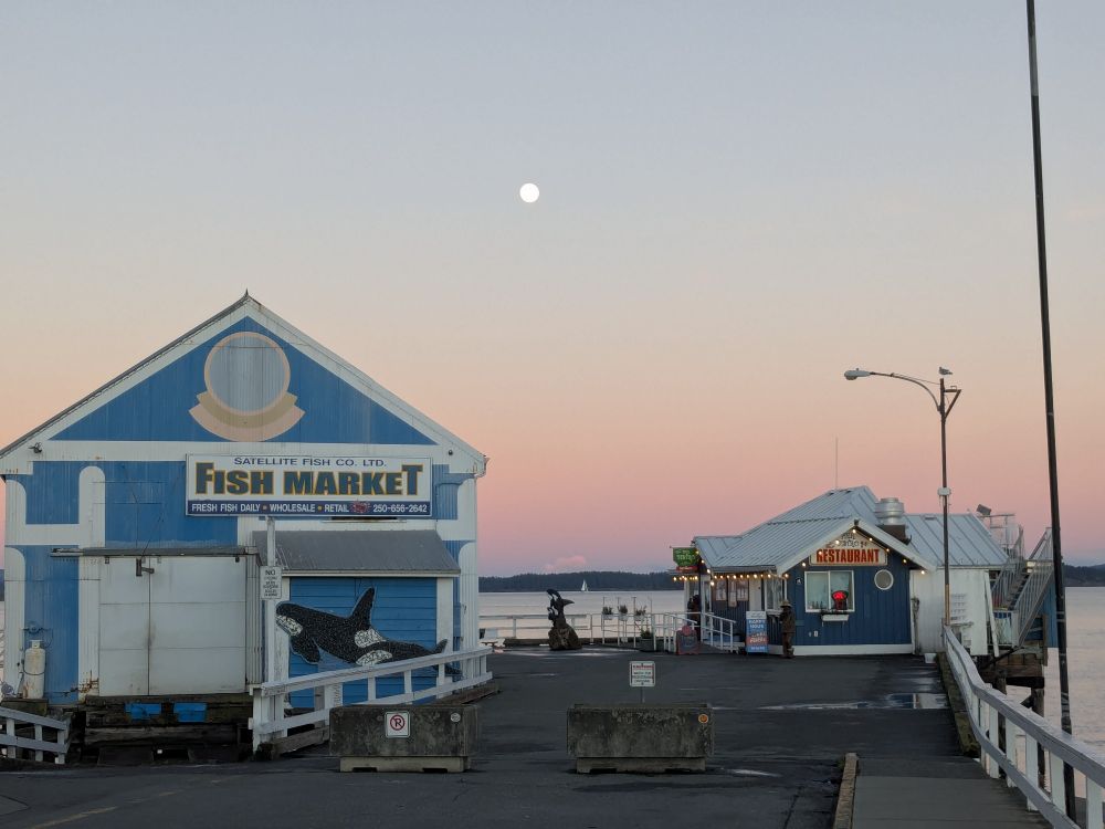 Sidney Pier with a fish market and a small restaurant.  The full moon rises behind.