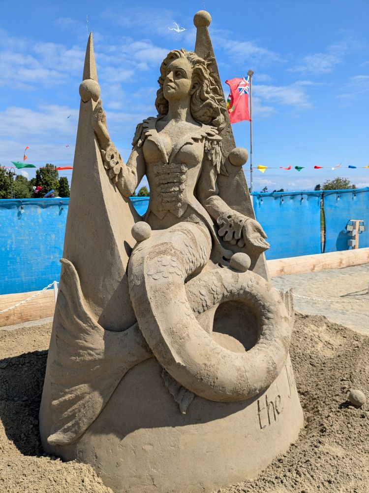 Sand Castle of a mermaid sitting atop a castle made of cones.