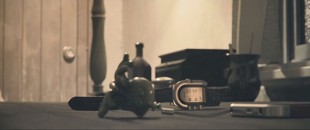 Still from the movie of Nyx's desk at eye level, focusing on the Lil Malbuddy phone charm and Crowe's "watch".