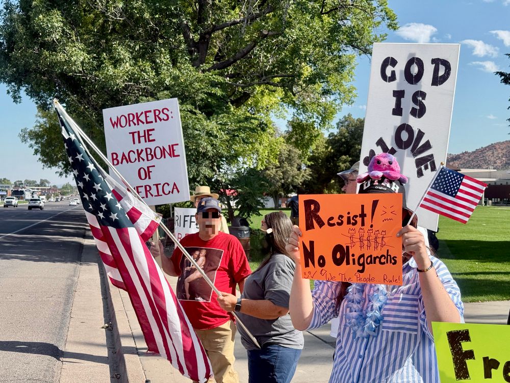Labor Day protesters, holding signs and American flags. Some sign say: 