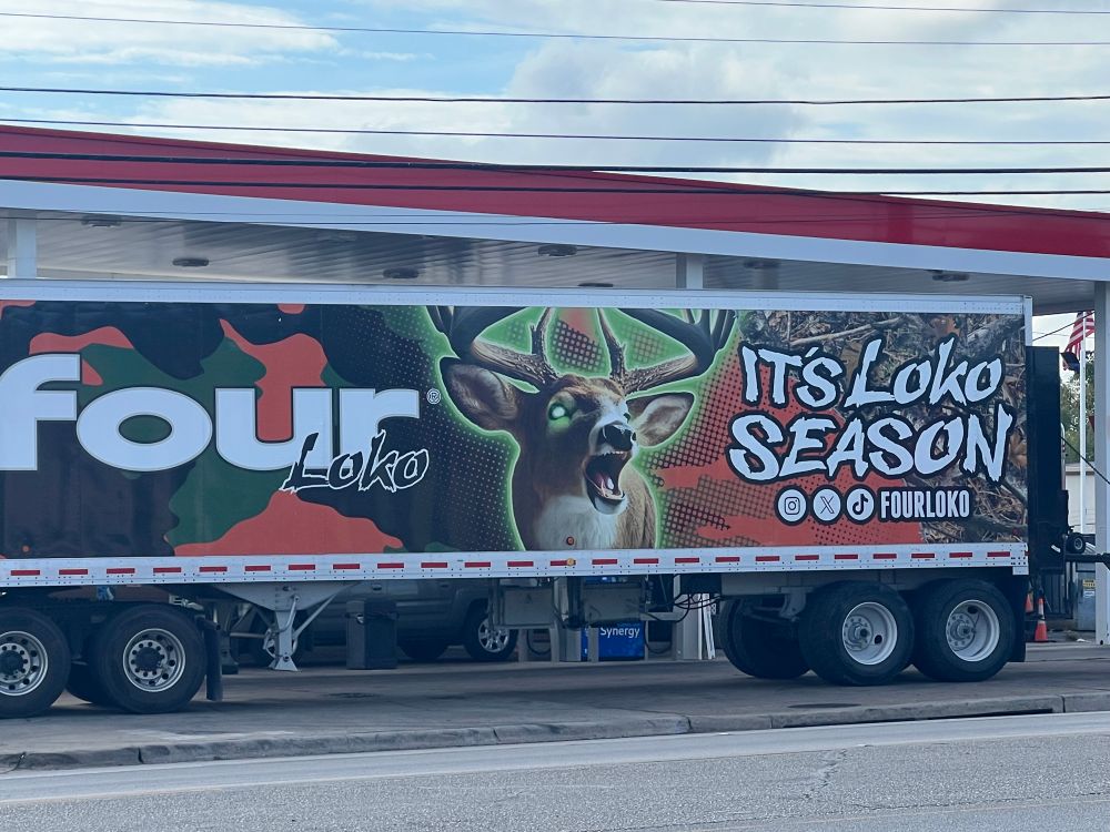 A Four Loko delivery truck side declaring ‘It’s Loko Season’ with a possessed, green-glowing deer.