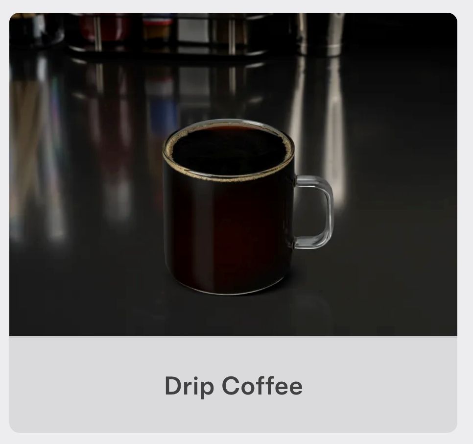 Photo of a glass cup filled to the brim with black coffee, on a black table, from the actual menu, that is incredibly unappealing and not at all 