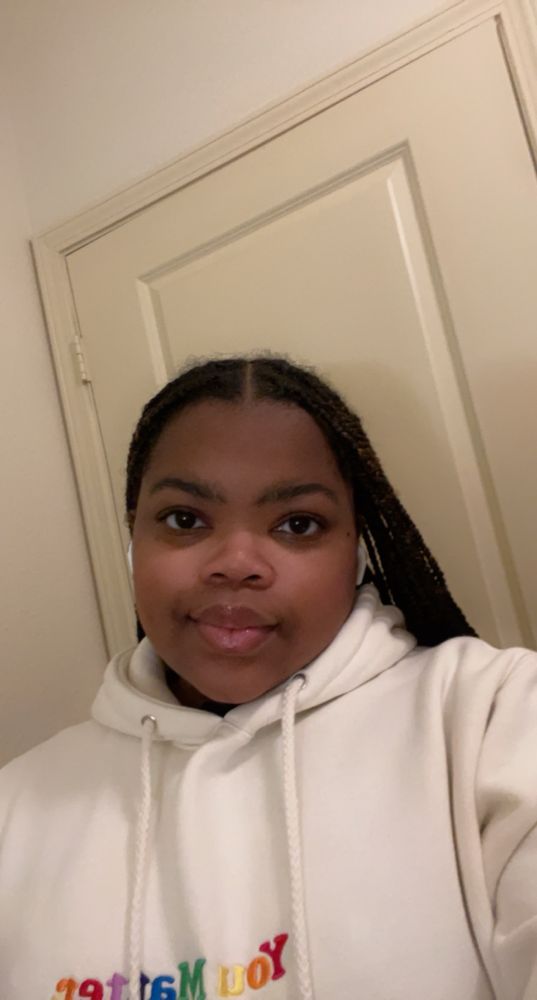 selfie of me smiling in front of a door 

I’m wearing a white/cream You Matter hoodie with rainbow colored letters