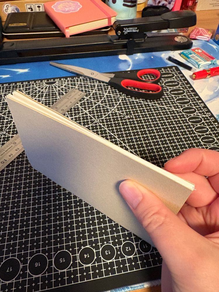 A photo of an A6 sketchbook held up to show the cutted edge.