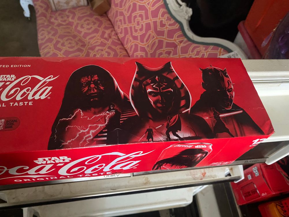 Limited Edition Star Wars Coke box with Star Wars Characters (right to left) Emperor Palpatine, Ahsoka, and Darth Maul. All characters are in red with red light sabers despite Ahsoka having a white lightsaber and being on the opposite side of the force from the other two characters.
