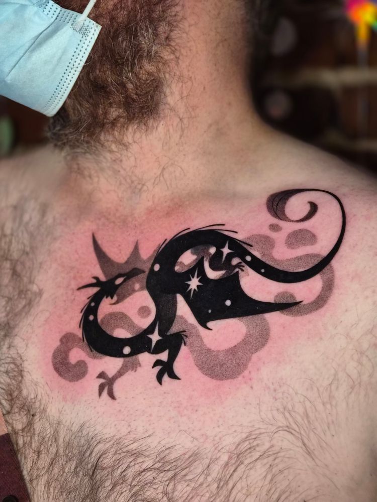 Tattoo of a black dragon filled with stars on light skin 
