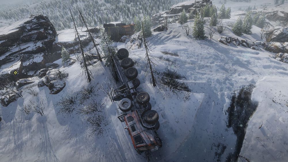 big ol' truck napping on its side in the snow with another truck also napping on its side in the snow in the background