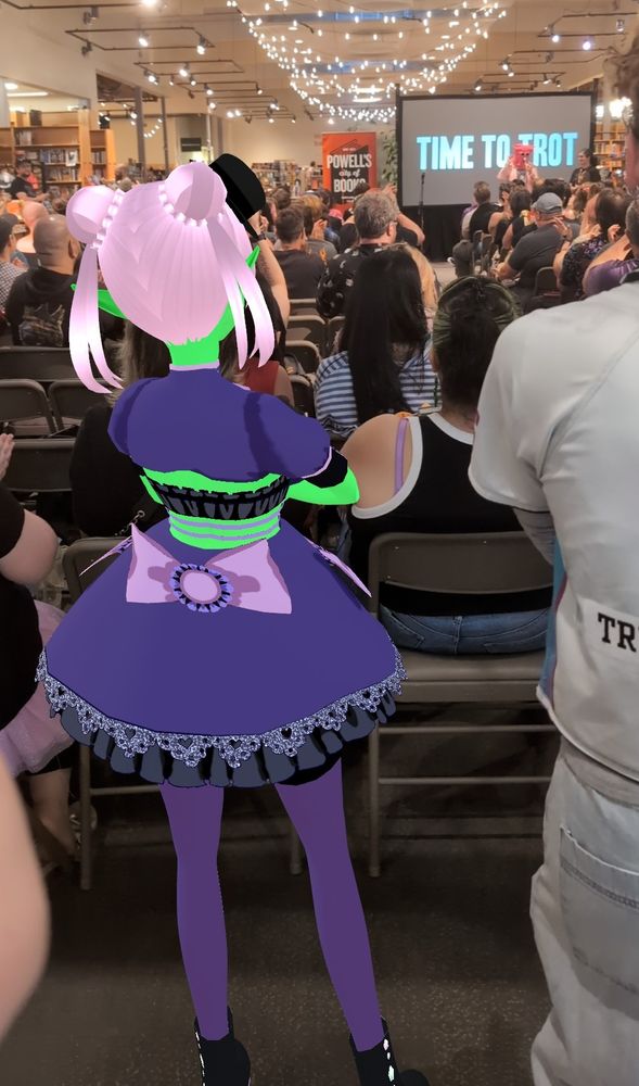 Noiz stands at the back of a crowd at a Powells bookstore watching Chuck Tingle, the writer.