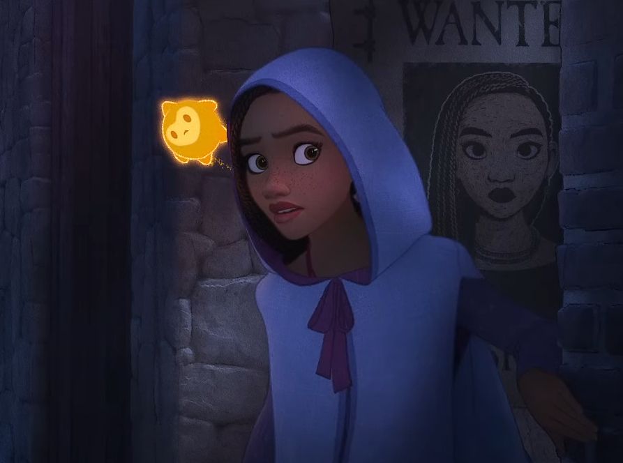 A movie still from Disney's "Wish" showing a hooded Asha sneaking past her wanted poster while Star looks over her shoulder.