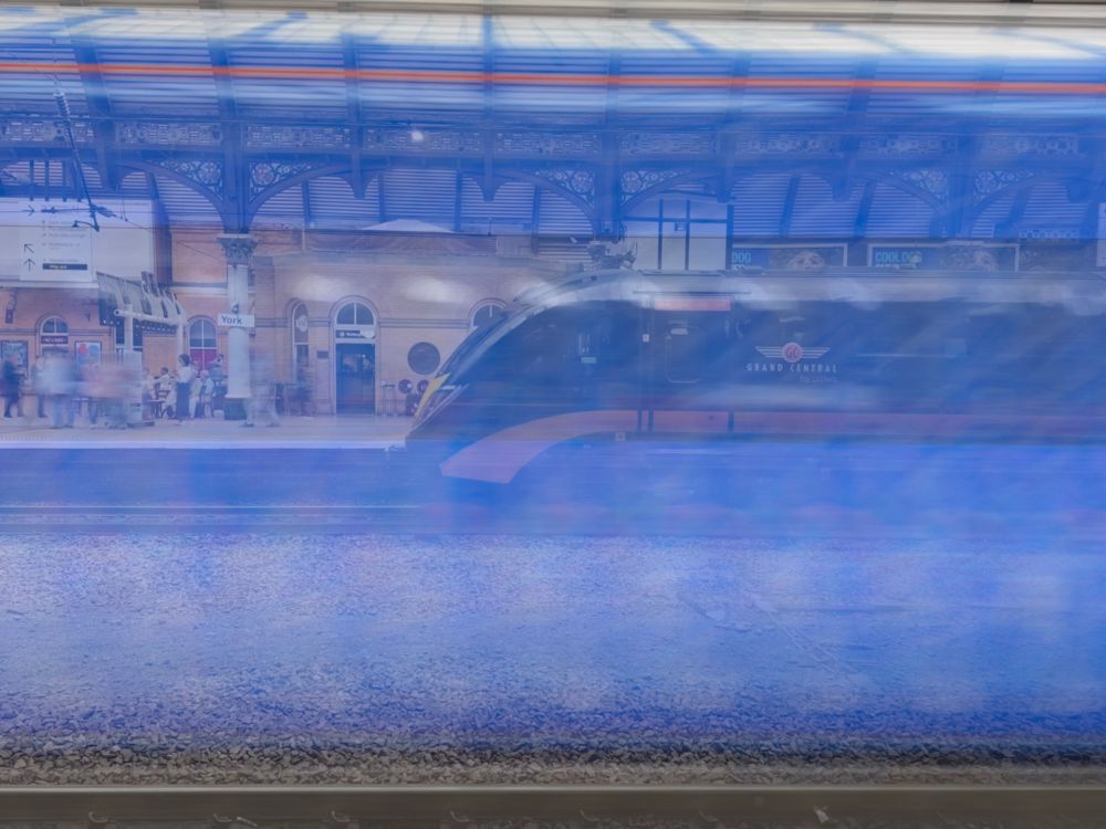 Using the long exposure function of the iphone14 a blue train passes in front of the camera while a Grand Central sits in Platform 4 at York, UK. 
