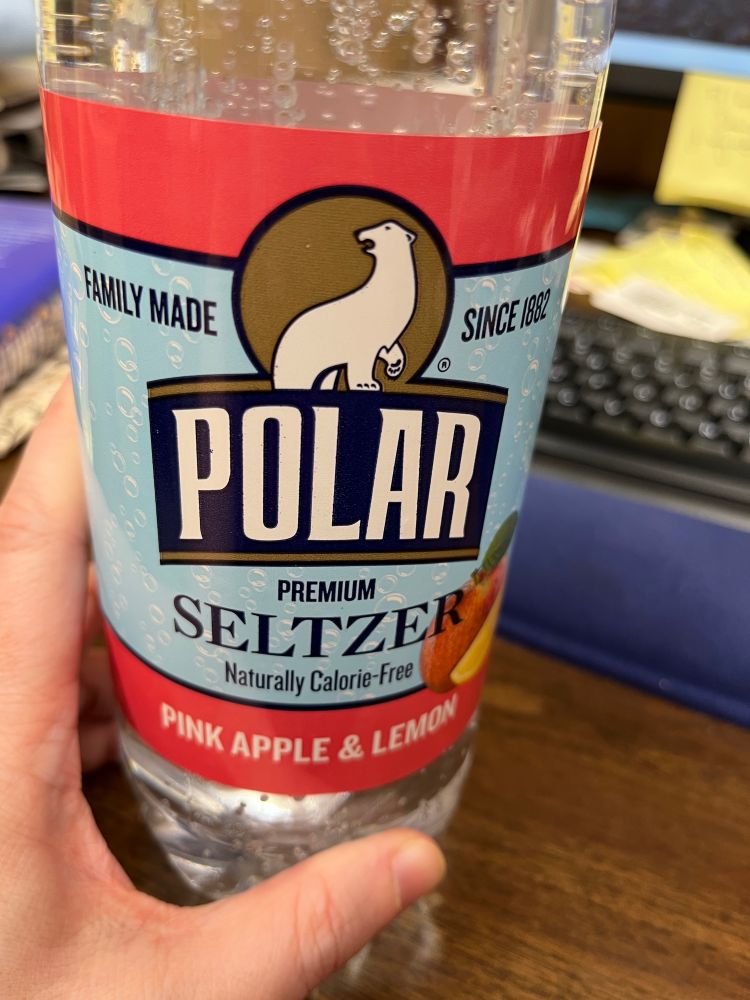 White girl hand holding Pink Apple & Lemon seltzer
