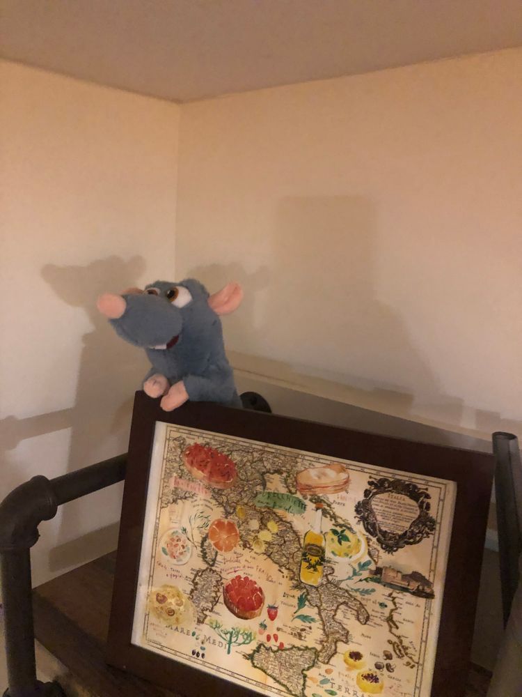 A stuffed animal Remy the rat from Pixar’s Ratatouille sits on a kitchen shelf.