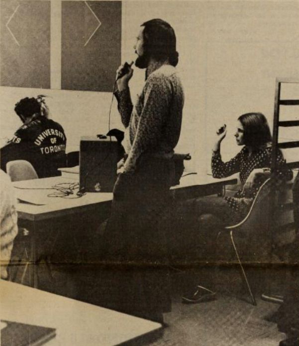 Miglin standing up and speaking in a classroom (vintage photo)