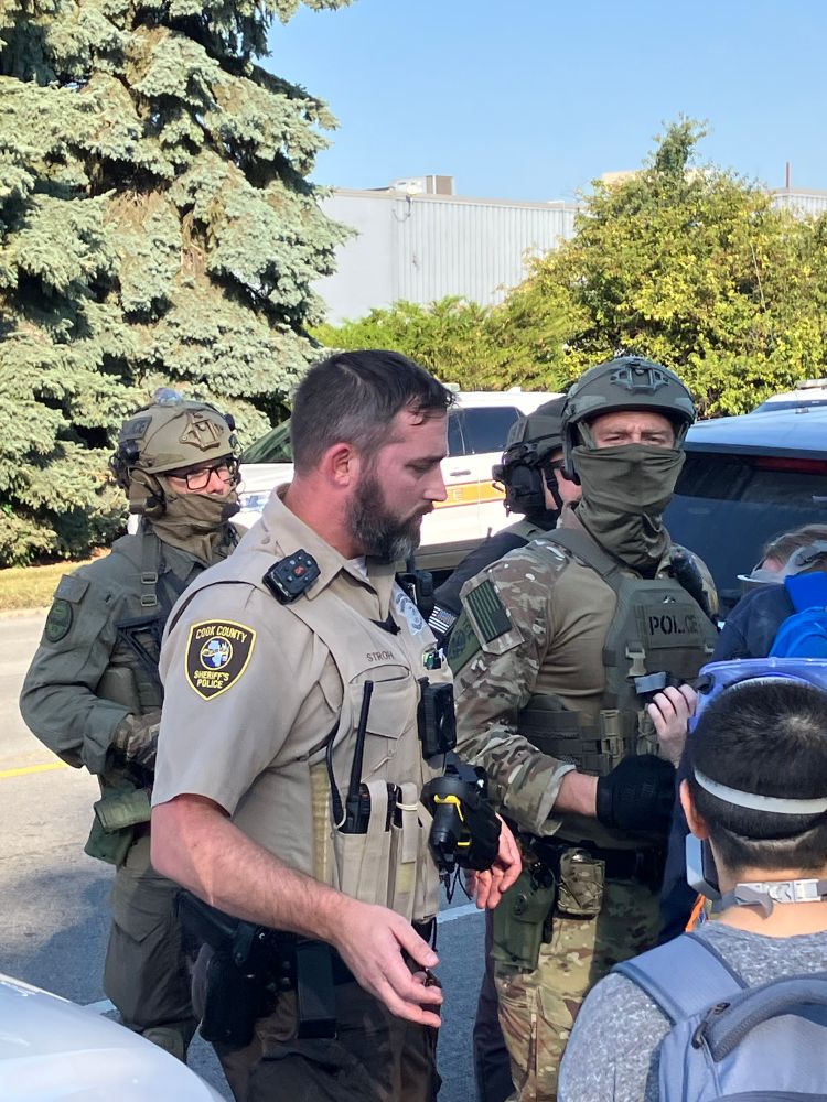cook county sheriff cop having a loving chat with two masked ICE goons