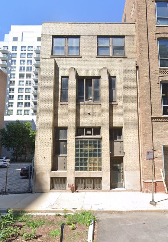 2024 streetview of 416 W. Erie, three story brick building with a big chunk of glass block and 2.5 story brick columns