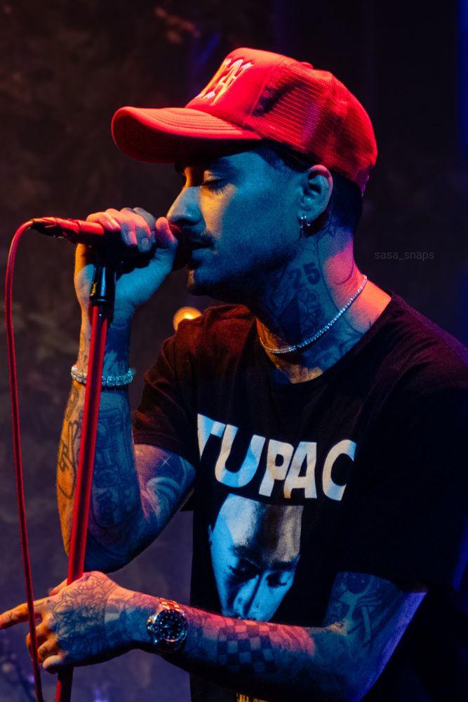 Zayn on stage with his eyes closed. He's seen from the side and the orange light casts a long shadow of his beautiful eyelashes on his cheek