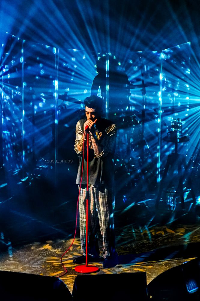 Zayn on stage surrounded by blue light beams