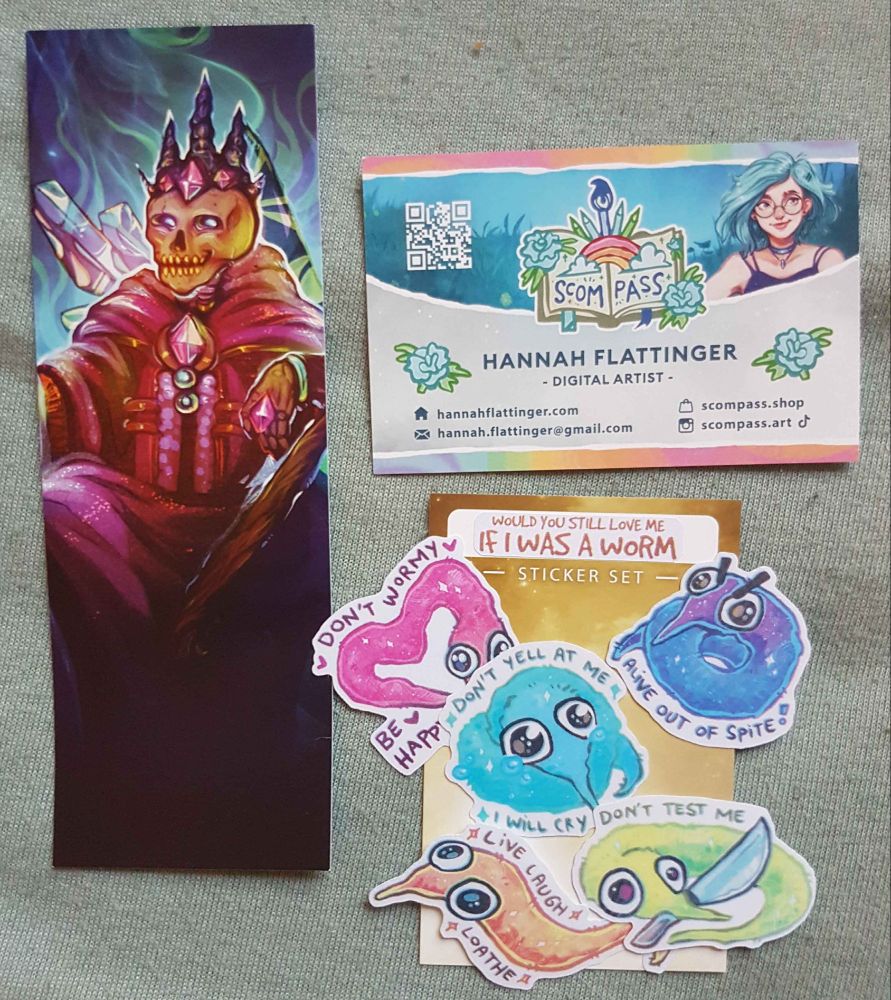 Bookmark of a skeleton wearing a crown and kings robes, and a set of stickers of colorful fuzzy worms