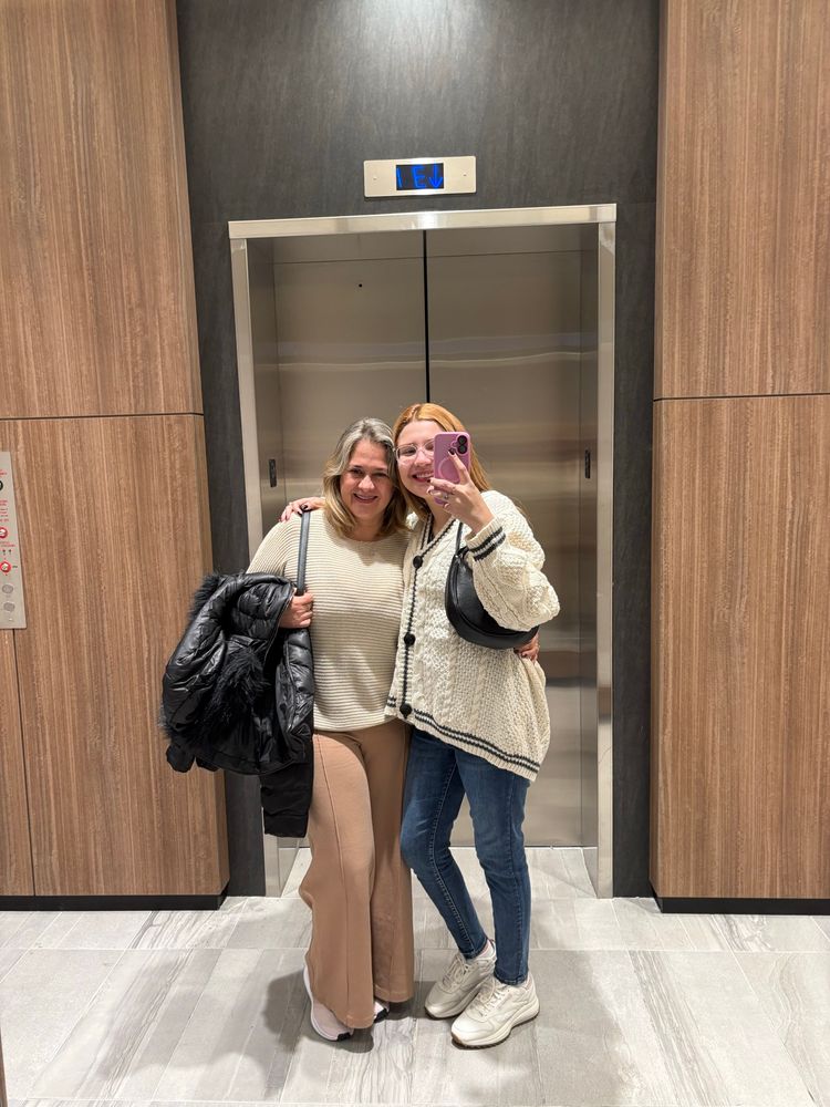 mirror selfie two woman in front of an elevator