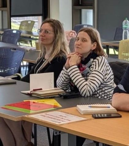 Sarah Spellman and Maria Gunko sitting at a table at the Association of Social Anthropologists' 2025 conference.