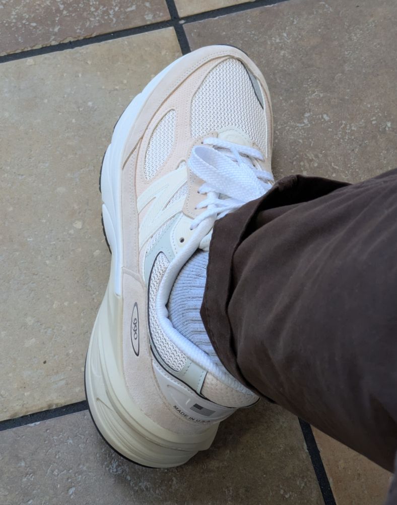 An on foot shot of the New Balance 990V6 in the vintage rose color way. I'm also wearing grey socks and dark brown pants 