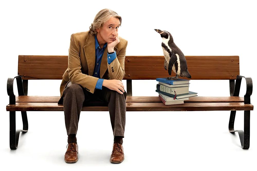 Man sitting on a bench with a penguin.