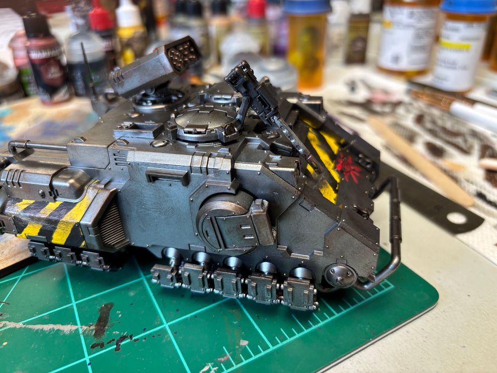 A Repulsor tank, with Iron Warriors stripes. A work in progress. It was base coated black and then airbrushed in Gunmetal. The rusty dirty color is dry-brushed Warplock Bronze. The crude red asterisk is defacement of the Imperial Aquila.