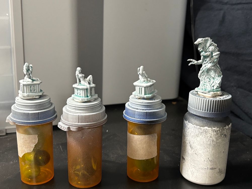 The Cobra King and three scantily clad ladies, from “Resurrection by Expansion.” They’re mounted on prescription bottles and primed in Seer Gray