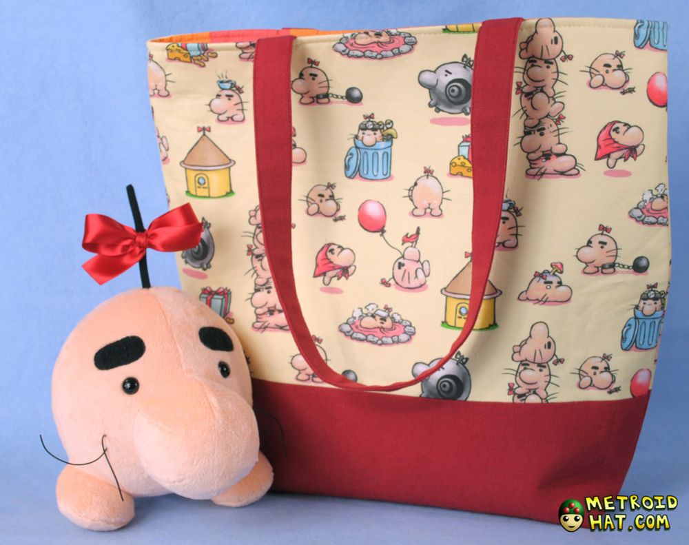 A tote bag made of red fabric and custom printed canvas. The print on it has Mr. Saturns from Earthbound in a number of poses. Like in a 5-stack ladder, hopped up on mushrooms, showing his butt, etc. I drew them and got the fabric printed! There's also a Mr. Saturn plushie I made, hanging out to help sell the photo.