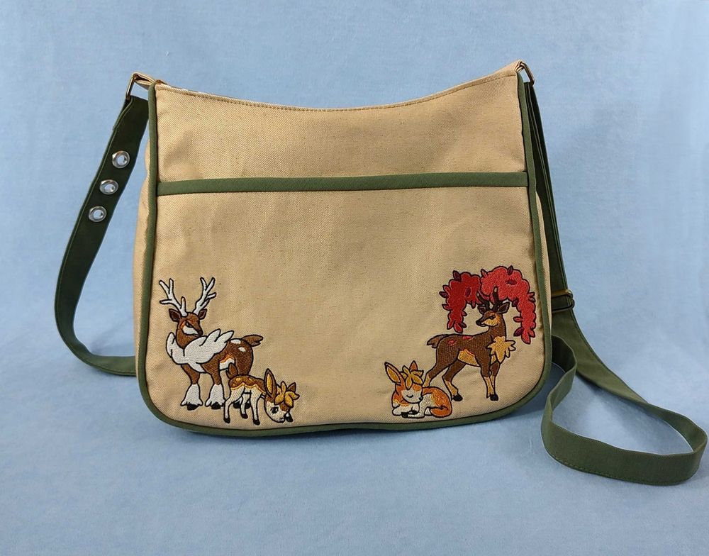 A beige shoulder bag with green-taupe piping and straps. I embroidered autumn and winter Sawsbucks and Deerlings on it. It was a gift to a friend who loves Pokemon and deer!