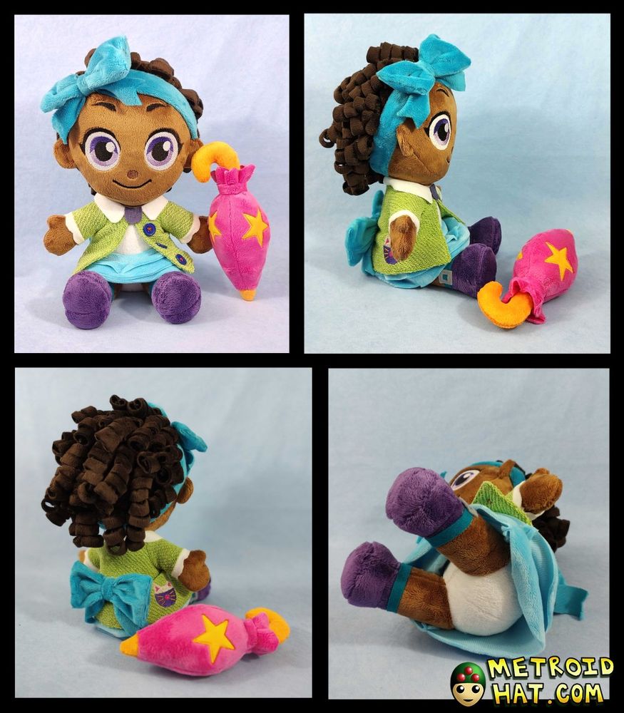 Bow Kid plushie prototype from four different angles. She's a big-eyed girl with dark curly hair held back by a blue ribbon headband, a collared green jacket, and a tiered blue skirt. One of the angles includes an upskirt shot, showing her white panties. Hey, it's not pervy! It's important to include these kinds of angles in the initial photoshoot, in case anyone has a problem with it. Because of course the customer will turn her around immediately and see the panties once Bow Kid is in their hands. The devs indeed wanted her panties changed into purple shorts. You're welcome, for my non-pervy insight.