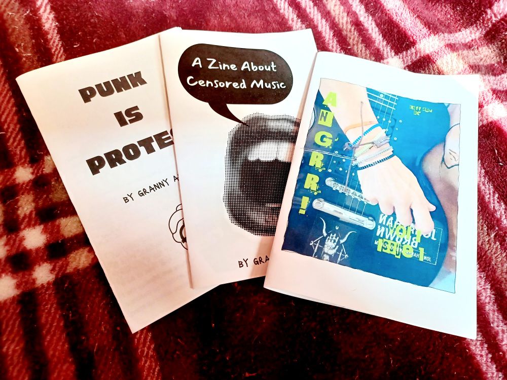 V1I1 of AnGrr!
A Zine About Censored Music 
Punk is Protest
zines on a red and white plaid blanket