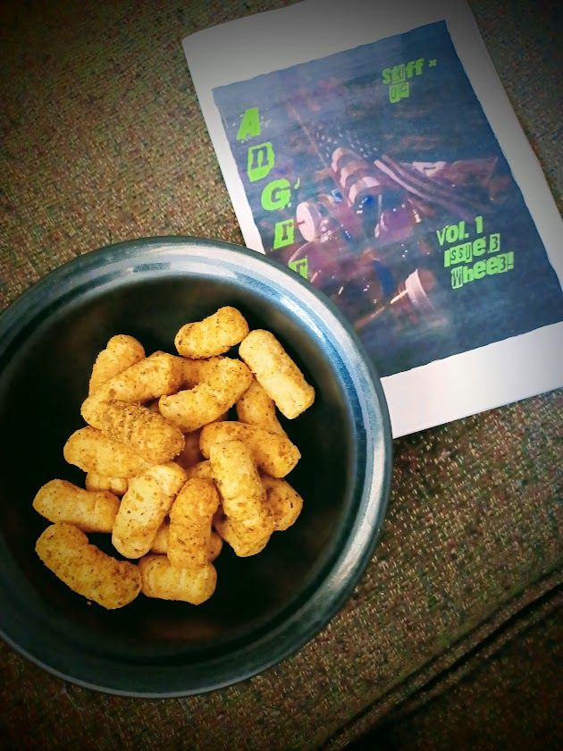 Front cover of AnGrr! (a Made in China [or Taiwan]) American Flag which the photographer found in the trash) by a bowl of cauliflower puffs