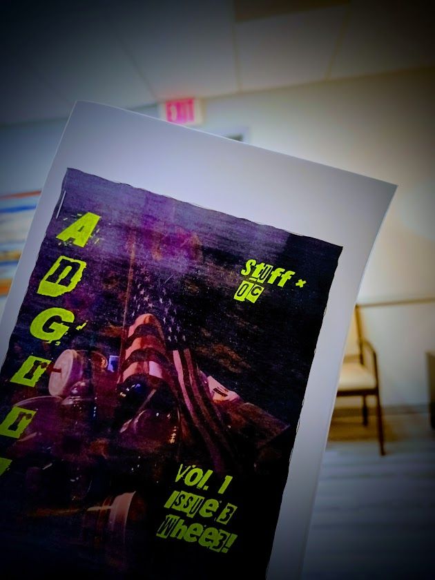 Front cover of AnGrr! (a Made in China [or Taiwan]) American Flag which the photographer found in the trash) in front of an EXIT sign
