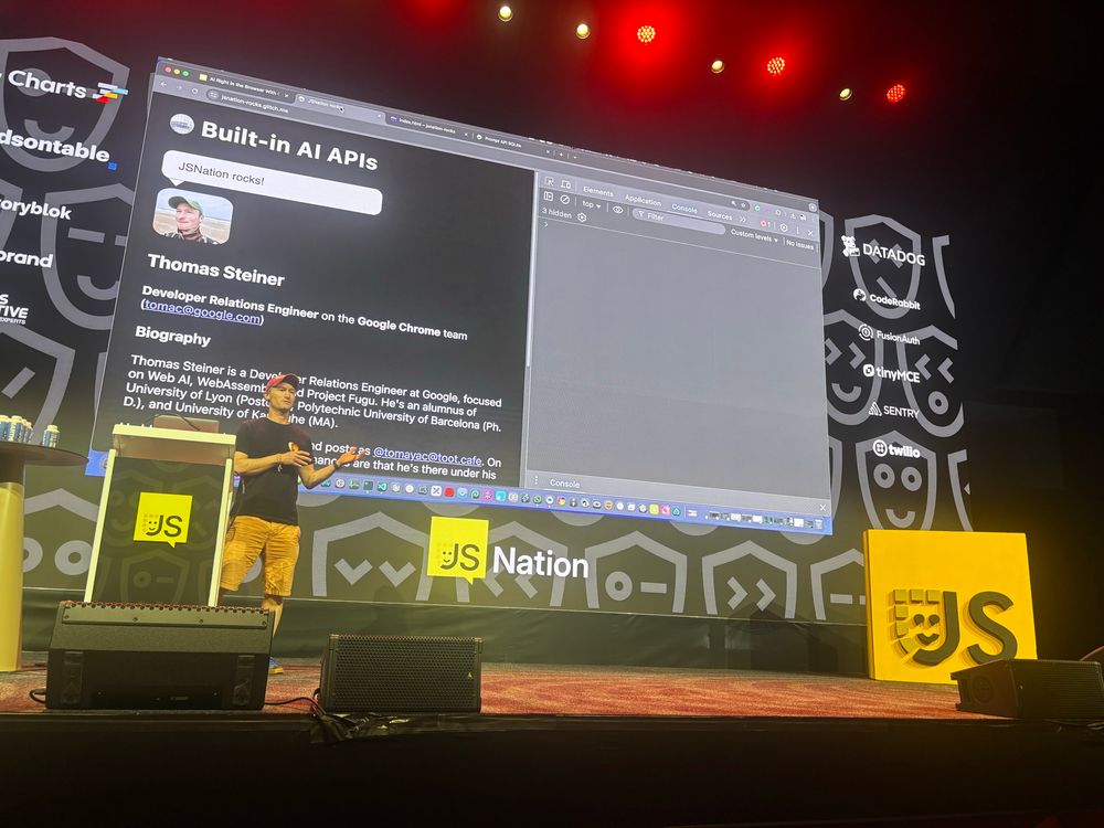 Thomas Steiner standing on stage in front of an example app running in the browser, with developer tools open ready to write live code.
