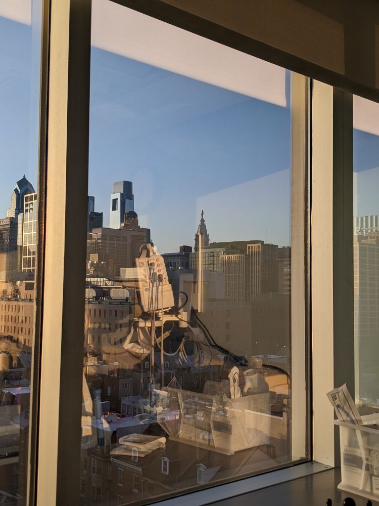View of Philadelphia from out of a hospital room window, the William Penn statue on top of City Hall peeking over the buildings.