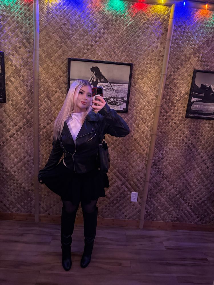 Jade in boots, stockings, skirt, jacket and purse 