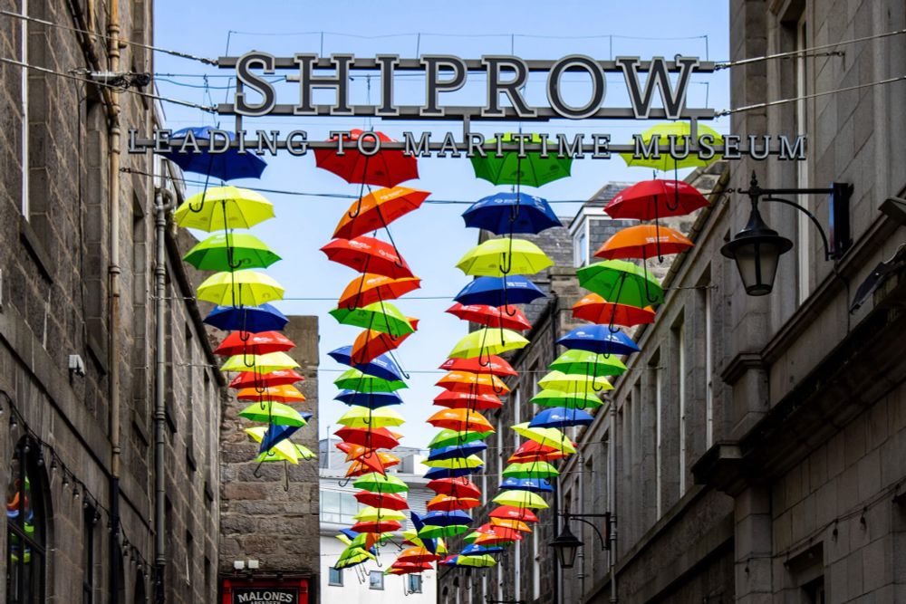Multicoloured Aberdeen Inspired umbrellas hanging above Shiprow.