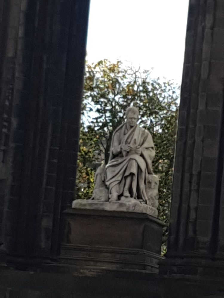 The statue of Walter Scott at the heart of the monument. It us made of white marble and shows Sir Walter sitting on a chair, wearing a flowing robe. His pose evokes a Roman philosopher or senator.